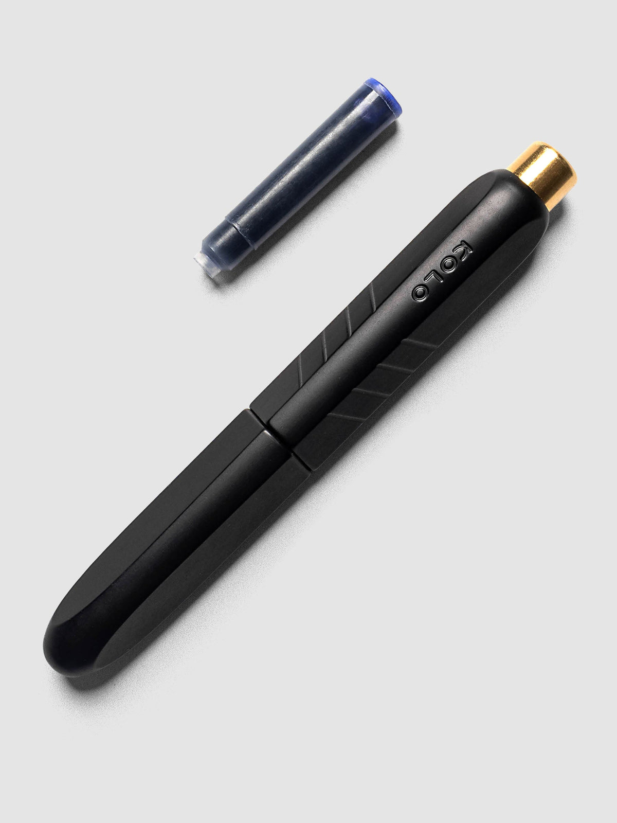 Kolo Tino Fountain Pen in Anodized Aluminum Noir shown cap on with ink cartridge resting beside pen