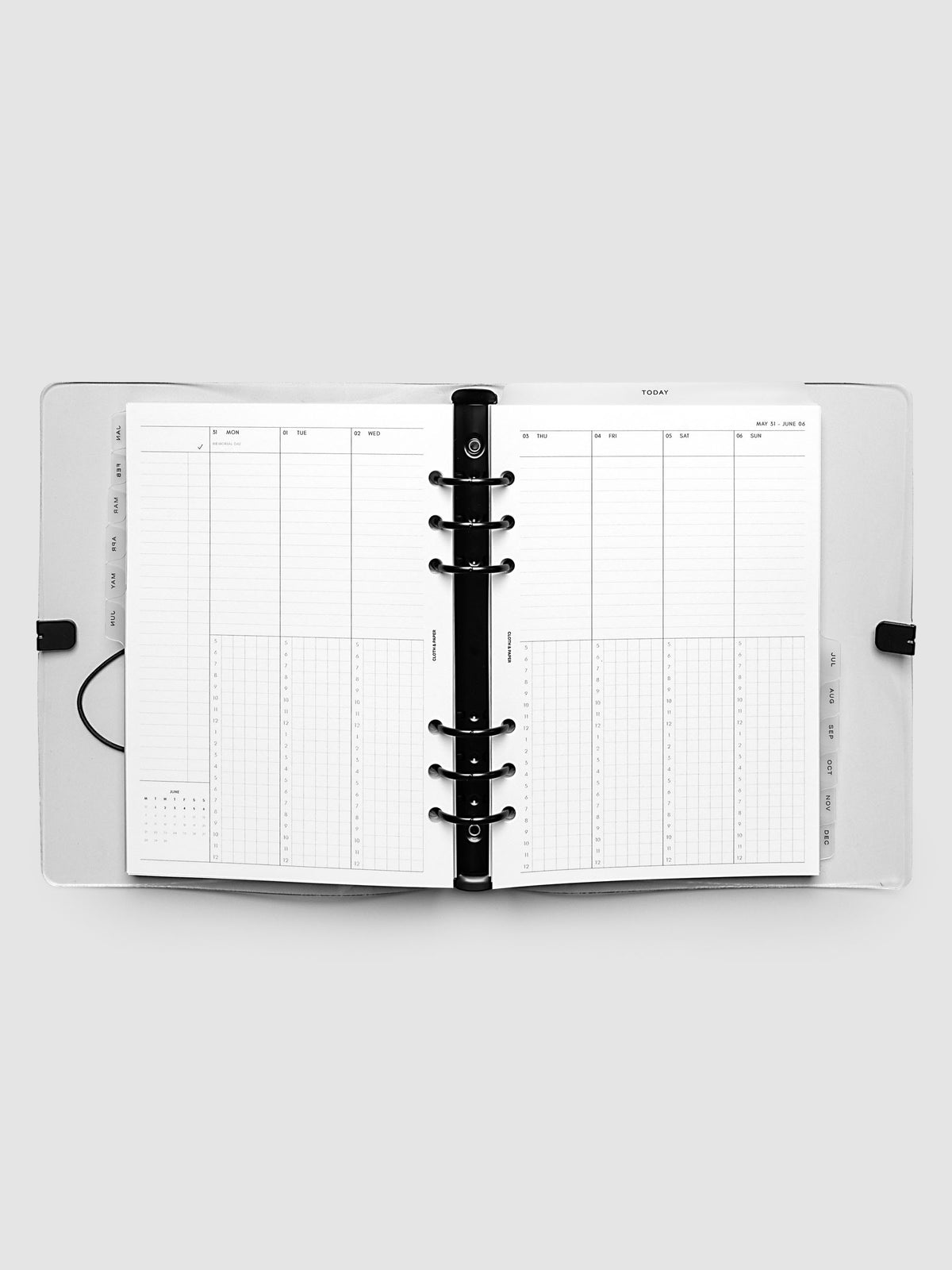 Flat lay of an open planner with black 6-ring binding at the center, a Monday through Sunday weekly time block spread across two facing pages with task lists, hourly grids, and a mini monthly calendar, A5 6-Ring Punch size