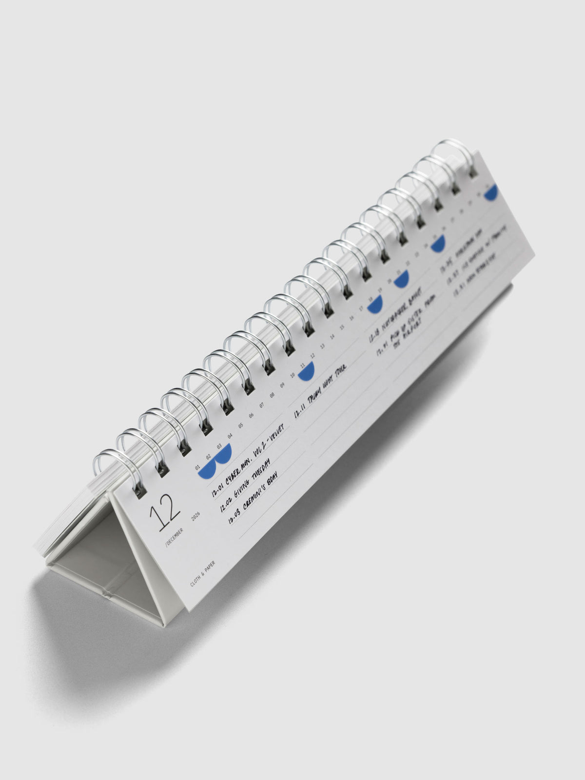 2026 Spiral Desk Calendar shown standing displaying a calendar page with stickers and handwritten notes.