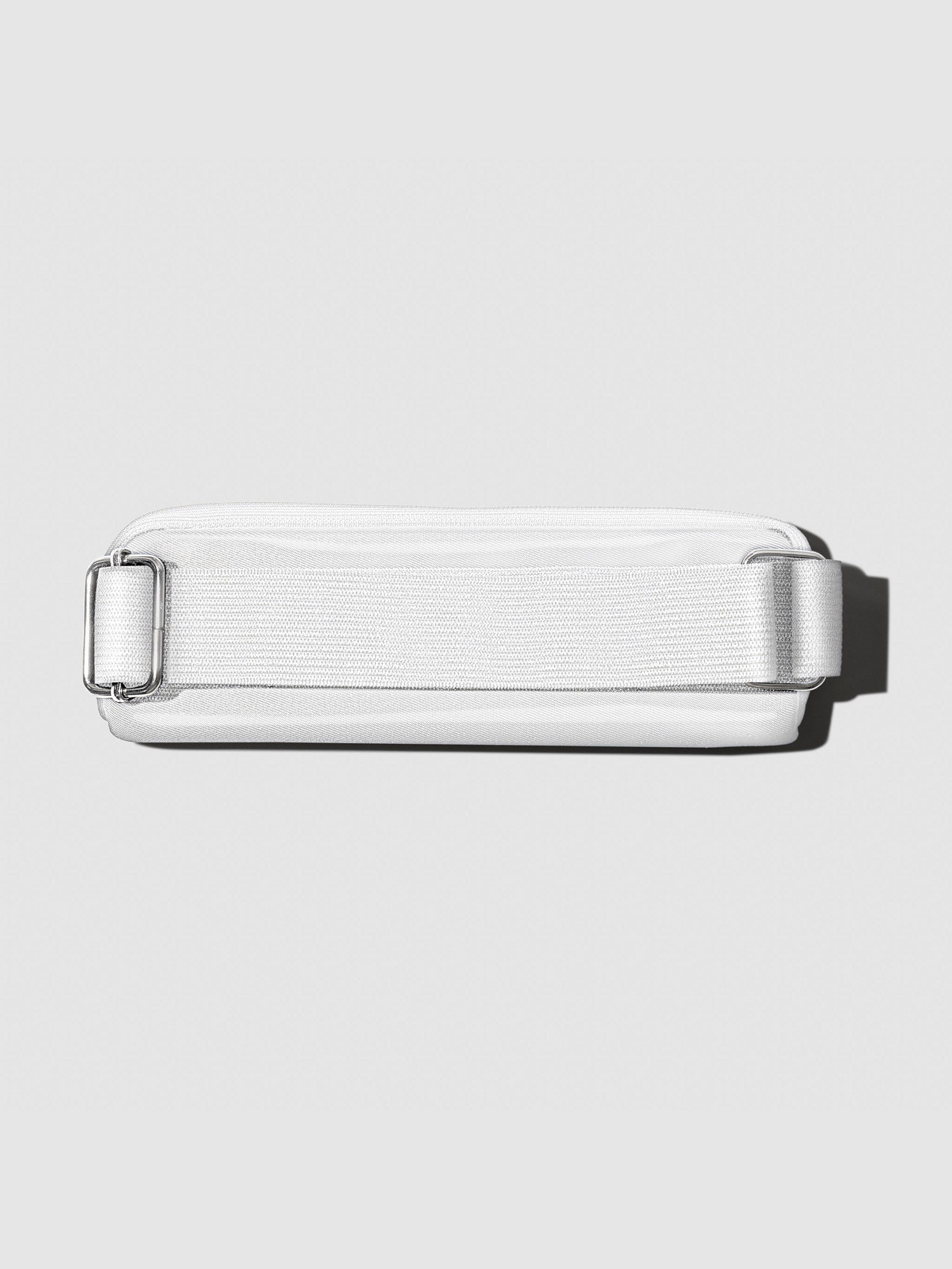Notebook pouch shown with its back facing forward to show the adjustable strap. Color shown is Le Blanc.