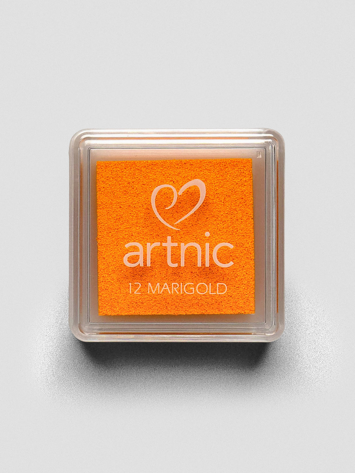 Square Artnic stamp ink pad in bright orange color labeled “12 Marigold,” with clear lid and white logo.