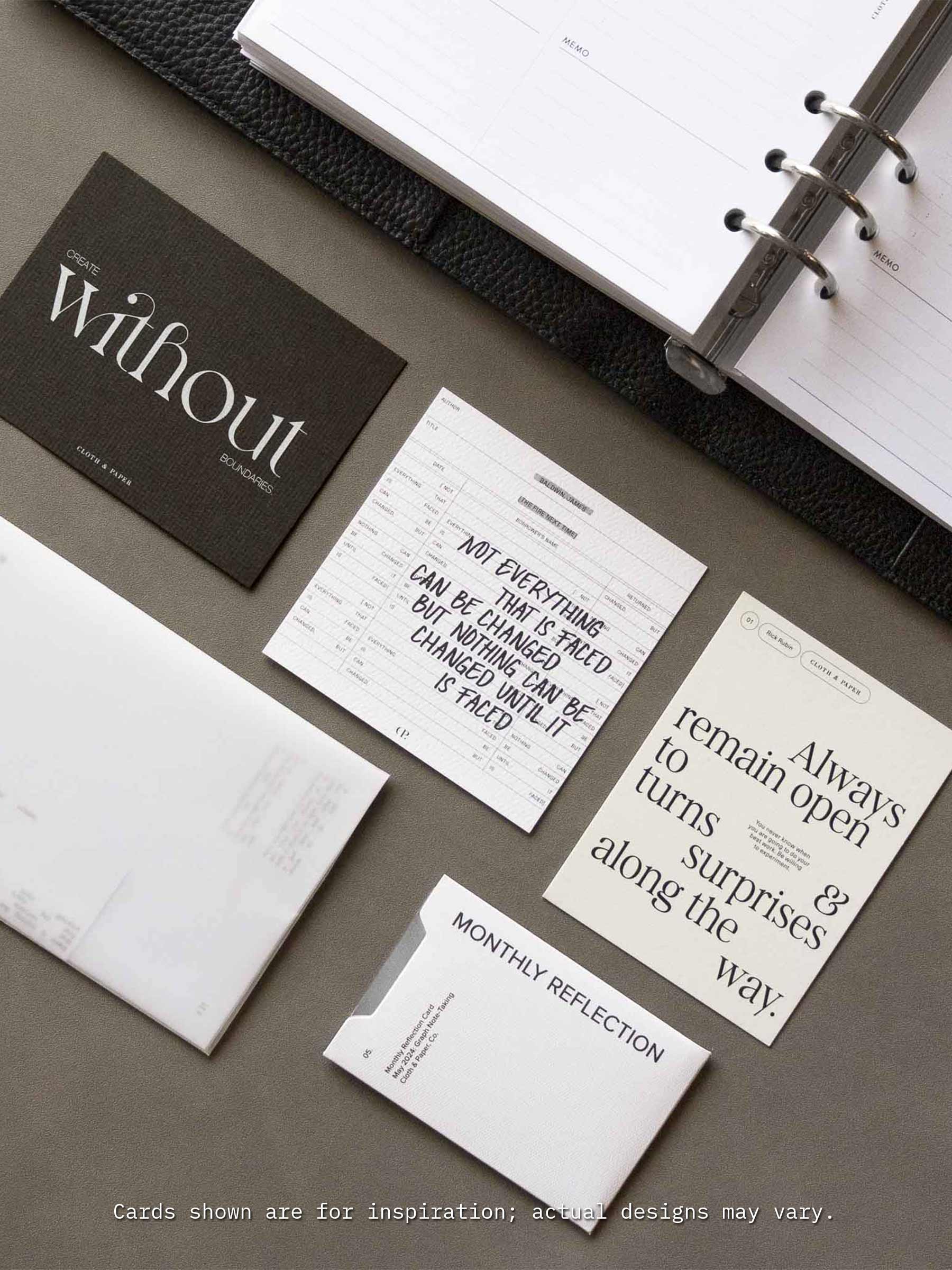 A flat lay of Cloth & Paper’s Assorted Journaling Card Set displayed next to an open planner, featuring neutral-toned cards with motivational quotes and minimalist typography, including cards labeled ‘Monthly Reflection’ and ‘Create without boundaries’.