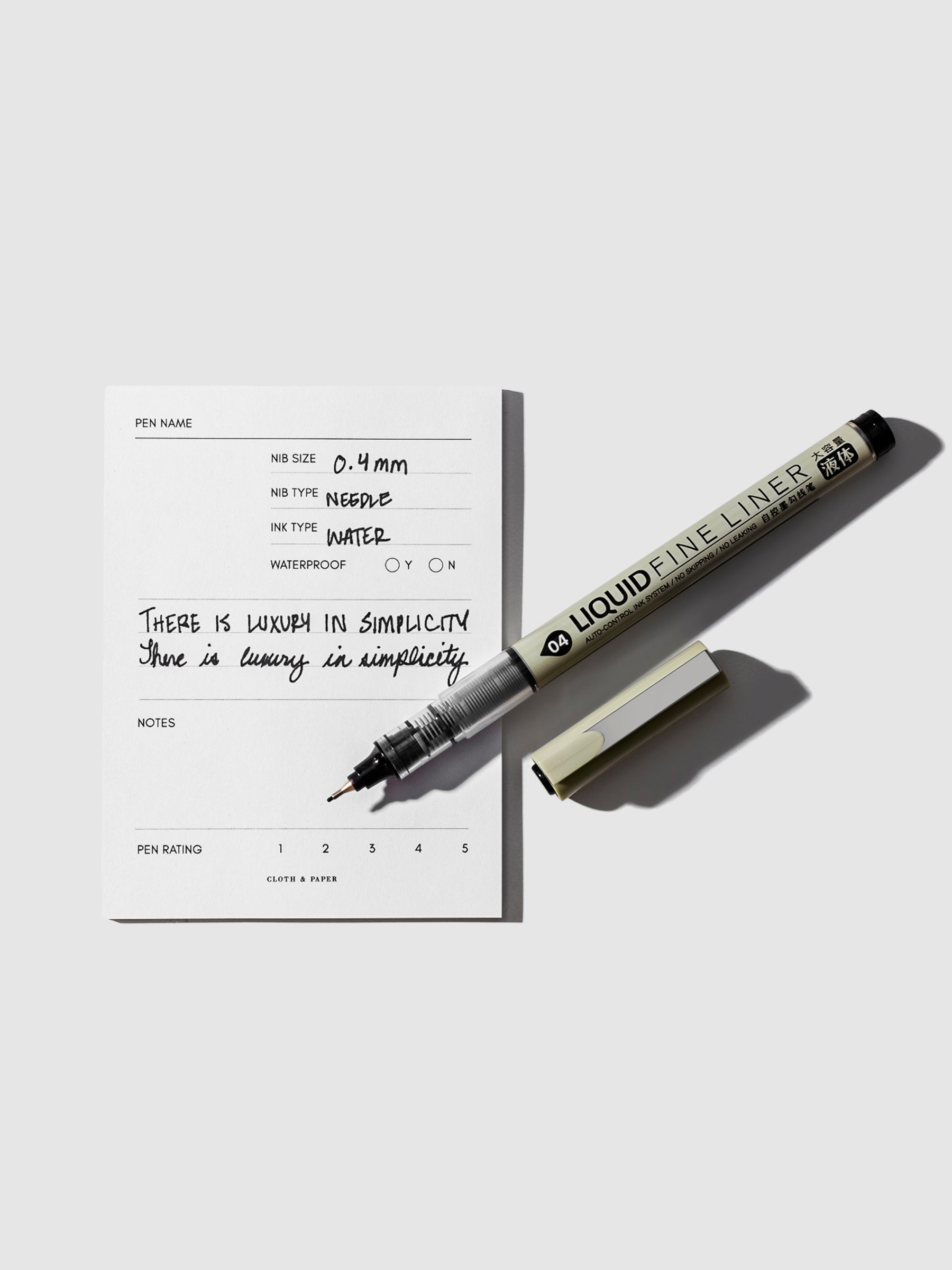 CEO Chic Liquid Fineliner with cap removed resting on a pen testing sticky note.