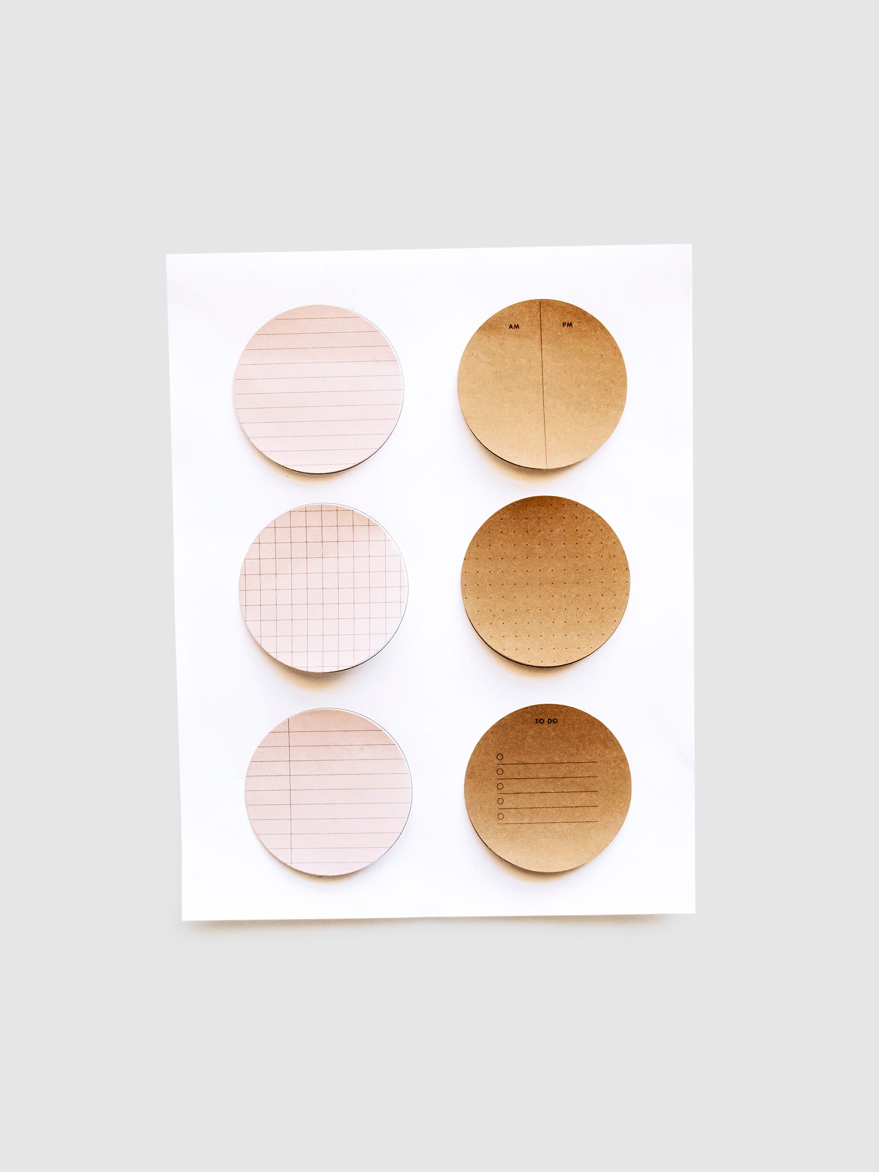 Brown and pink sticky notes printed using Circle Sticky Note Printables, stuck to their printing guide sheet.