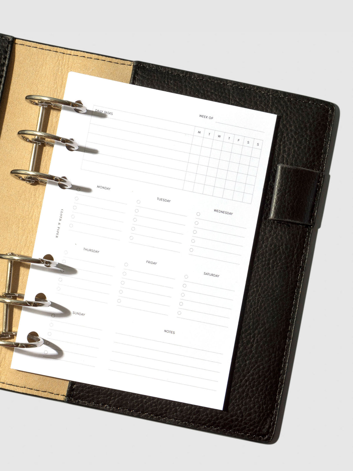 A6 sized inserts placed inside of a black leather folio with silver planner rings.