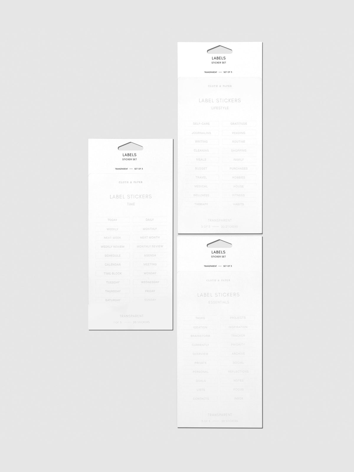 Clear Label Stickers, Silver, Cloth and Paper. 3 sheets of stickers arranged together on a neutral background.