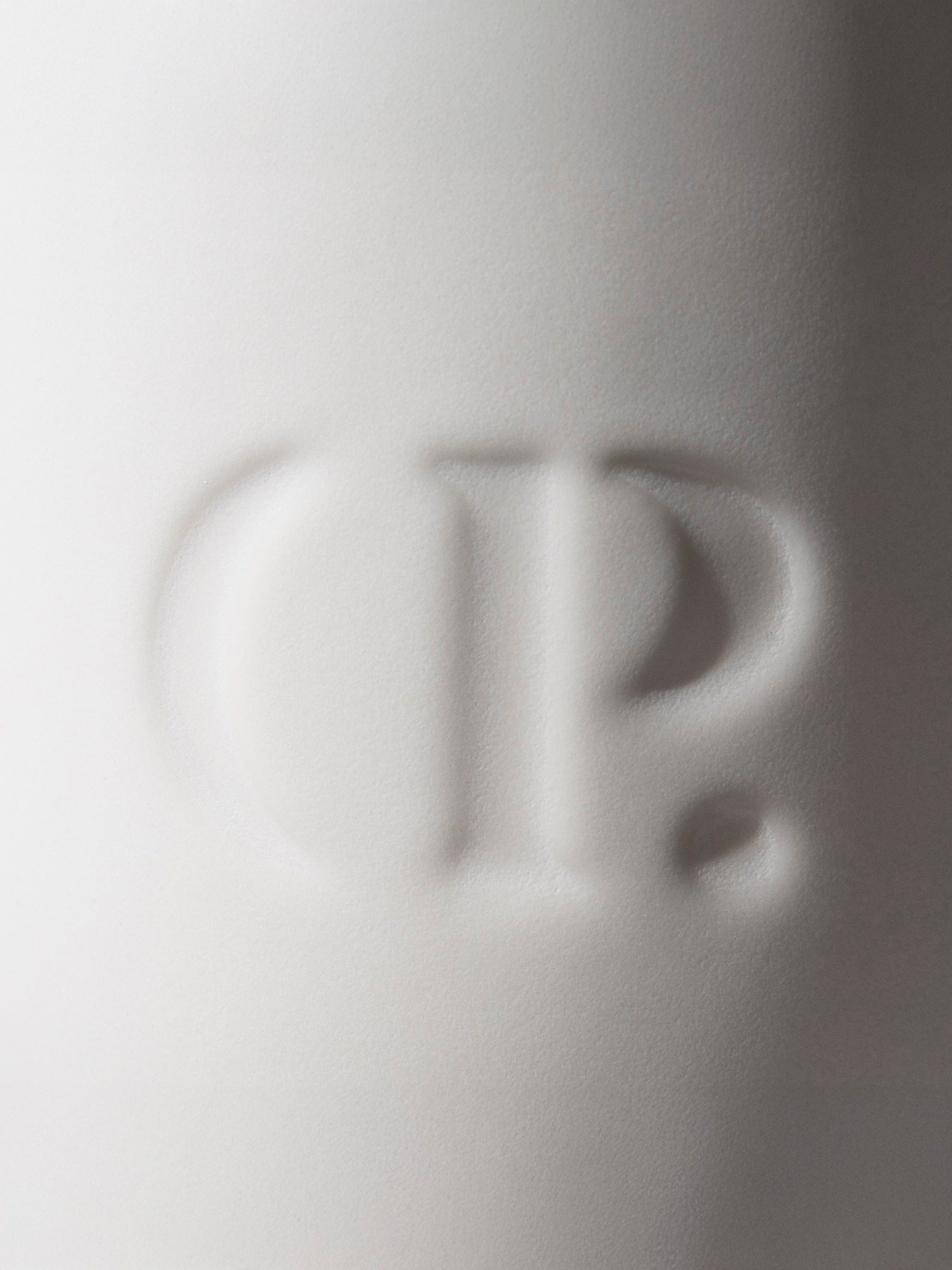 Closeup of embossed Cloth and Paper logo on the mug.