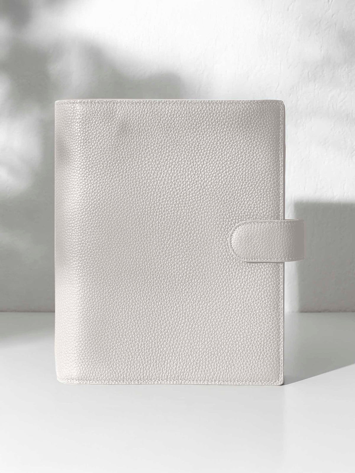 Ash leather agenda displayed displayed against a shadowed background.