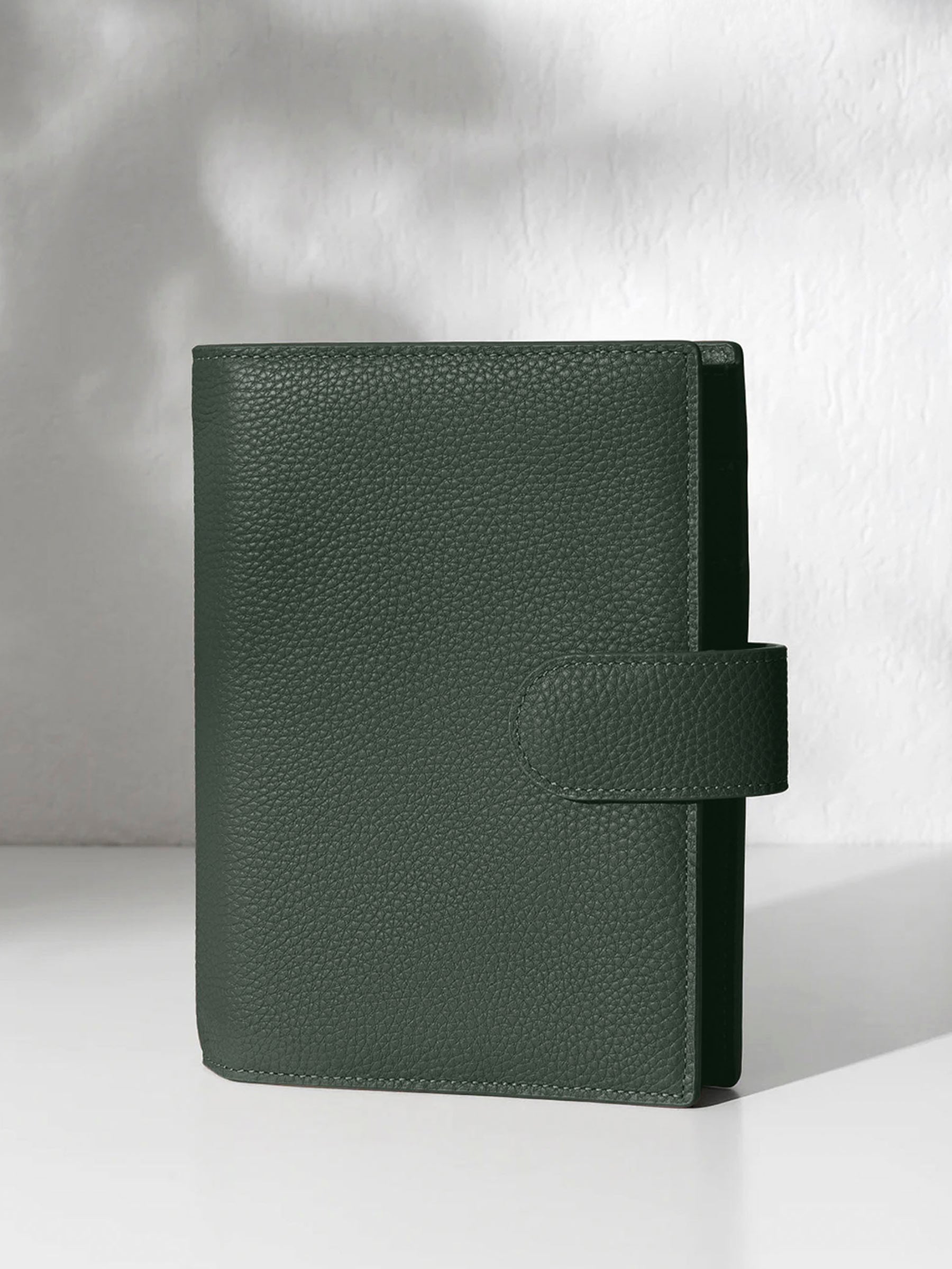 Closed cypress leather agenda displayed against a shadowed background.