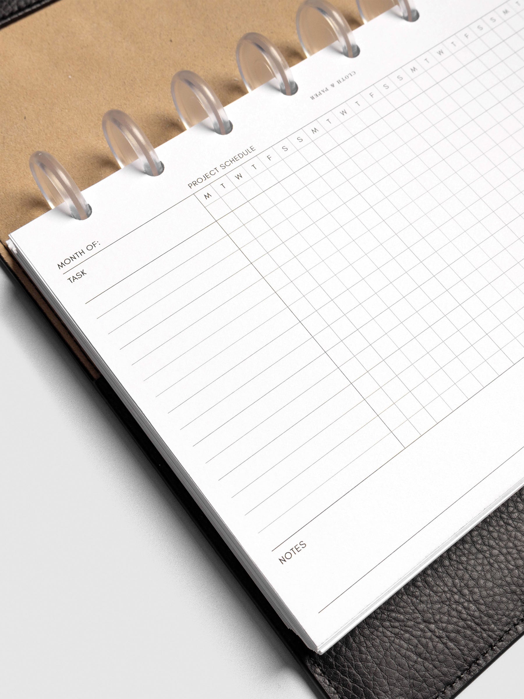 Close up of GanttChart inserts inside discbound planner and leather cover. 