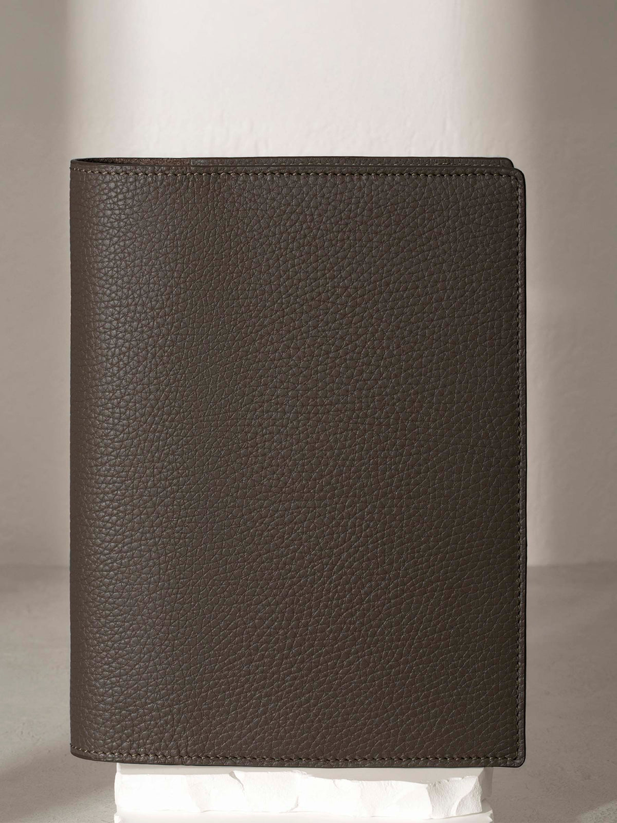 Leon  folio displayed on a white pedestal.