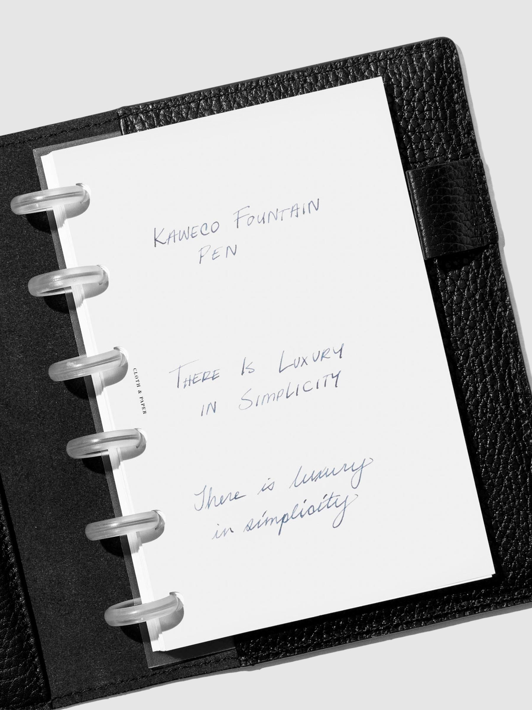 Fine  nib writing sample shown in a black leather folio.