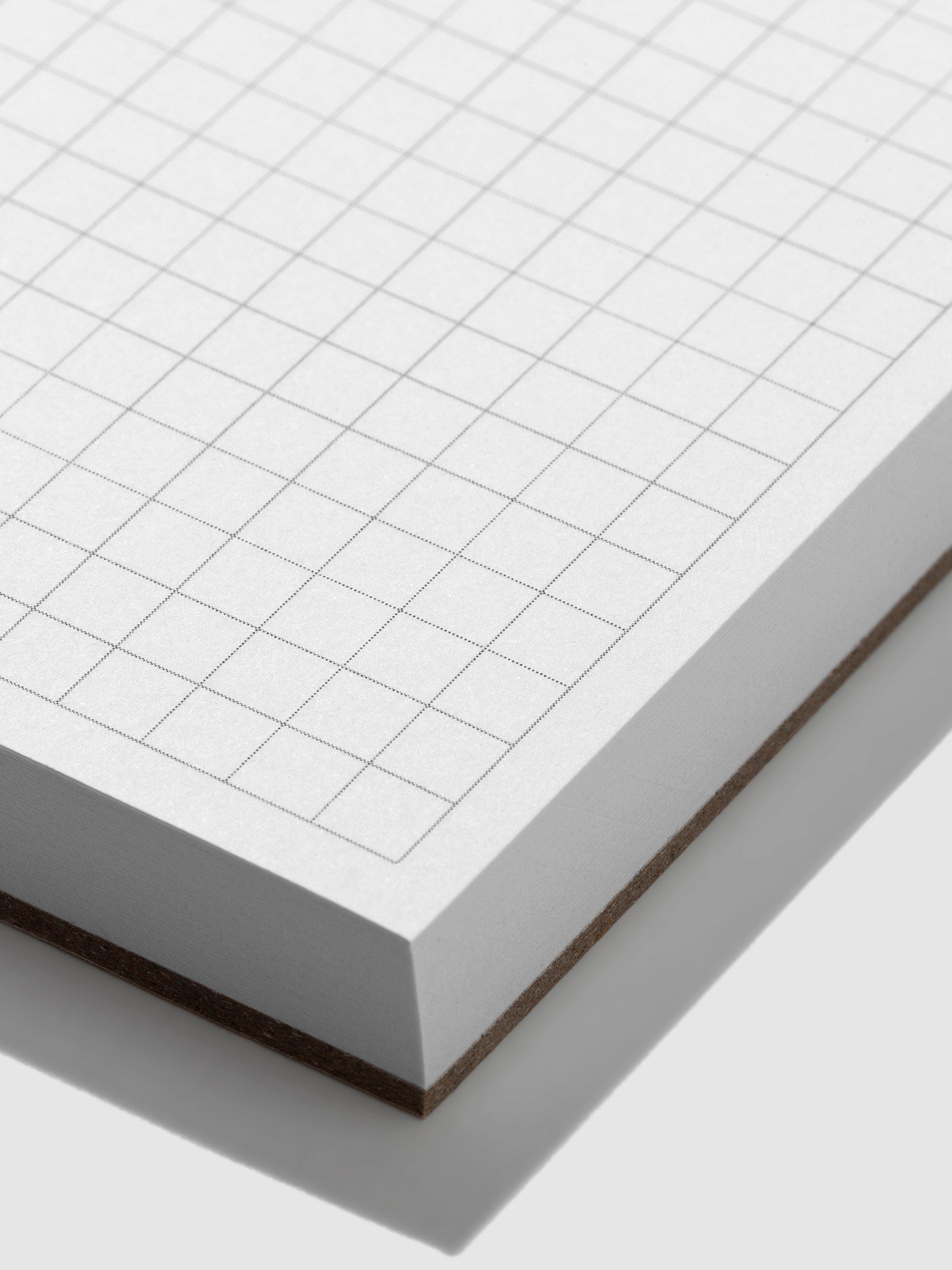 Closeup of the graph grid paper on the notepad.