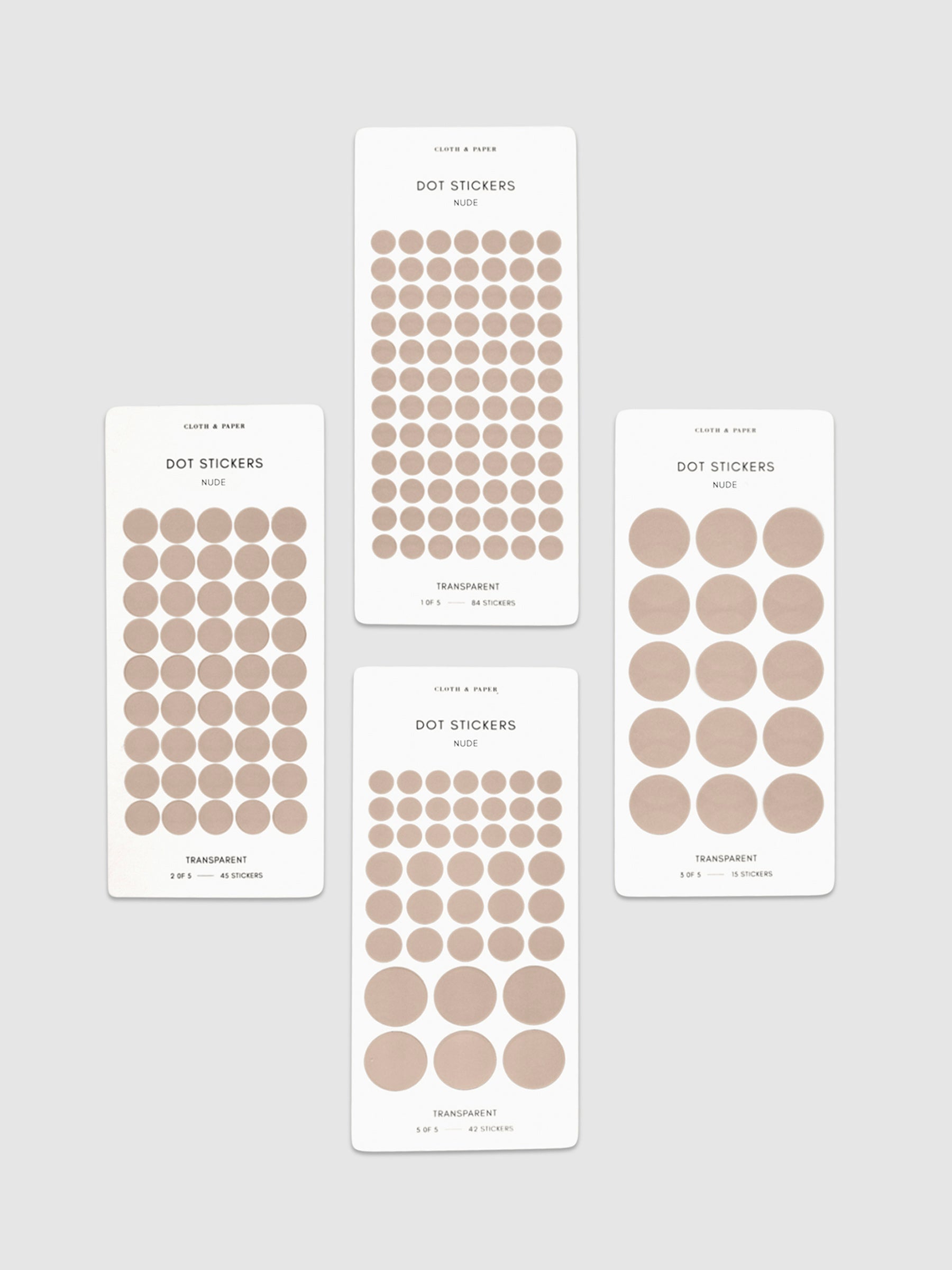 Four sheets of Nude dot stickers with varying sizes placed parallel to each other on a neutral background.