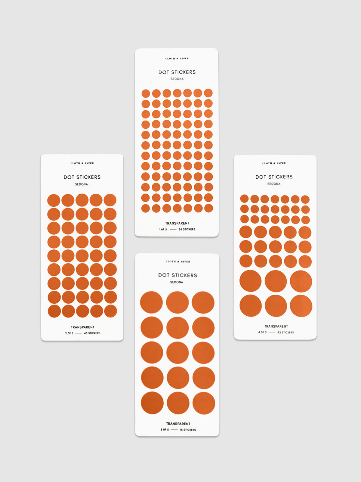Four sheets of Sedona dot stickers with varying sizes placed parallel to each other on a neutral background.