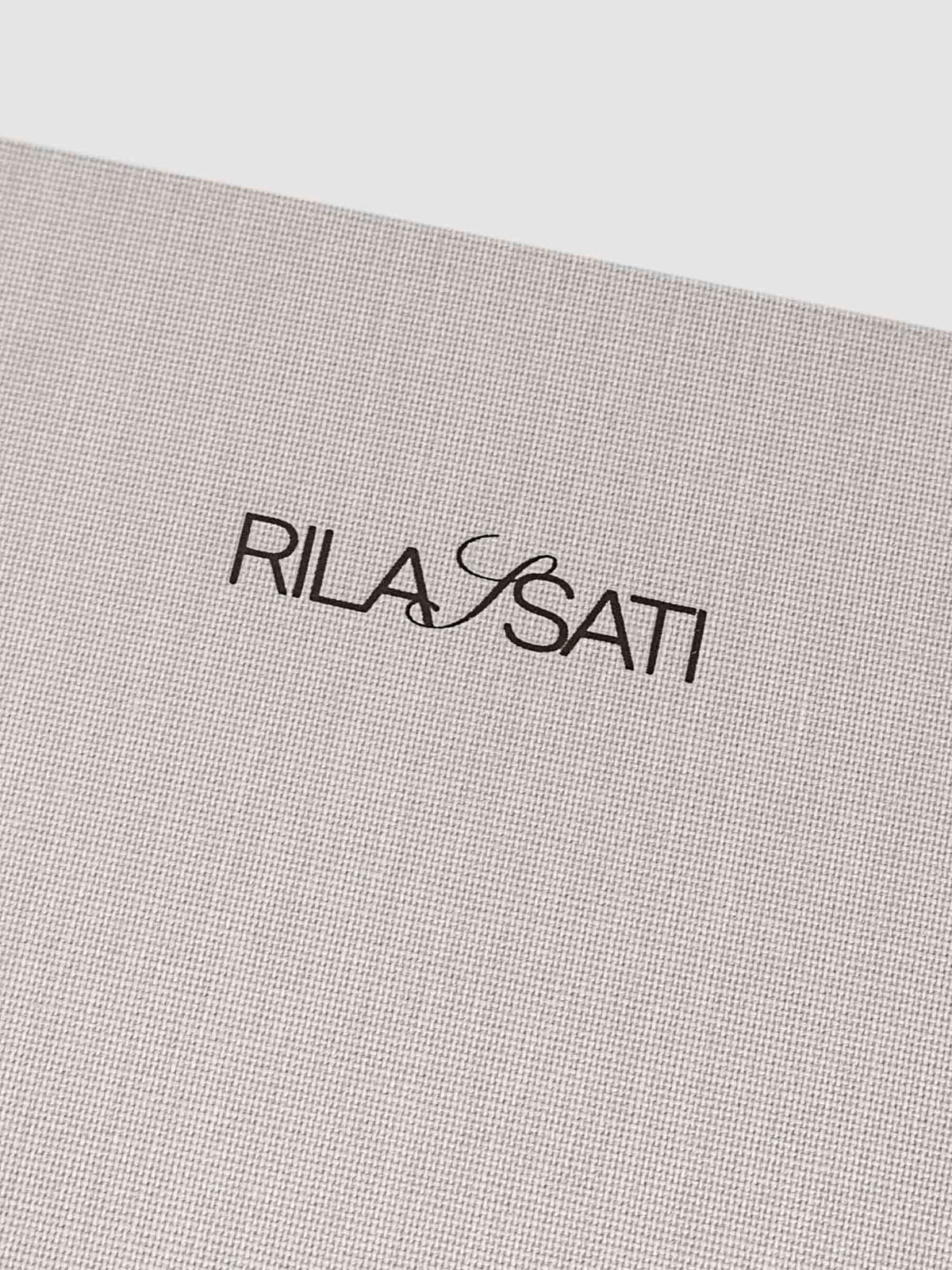 Closeup of fabric detailing and Rilassati printed logo on folio.