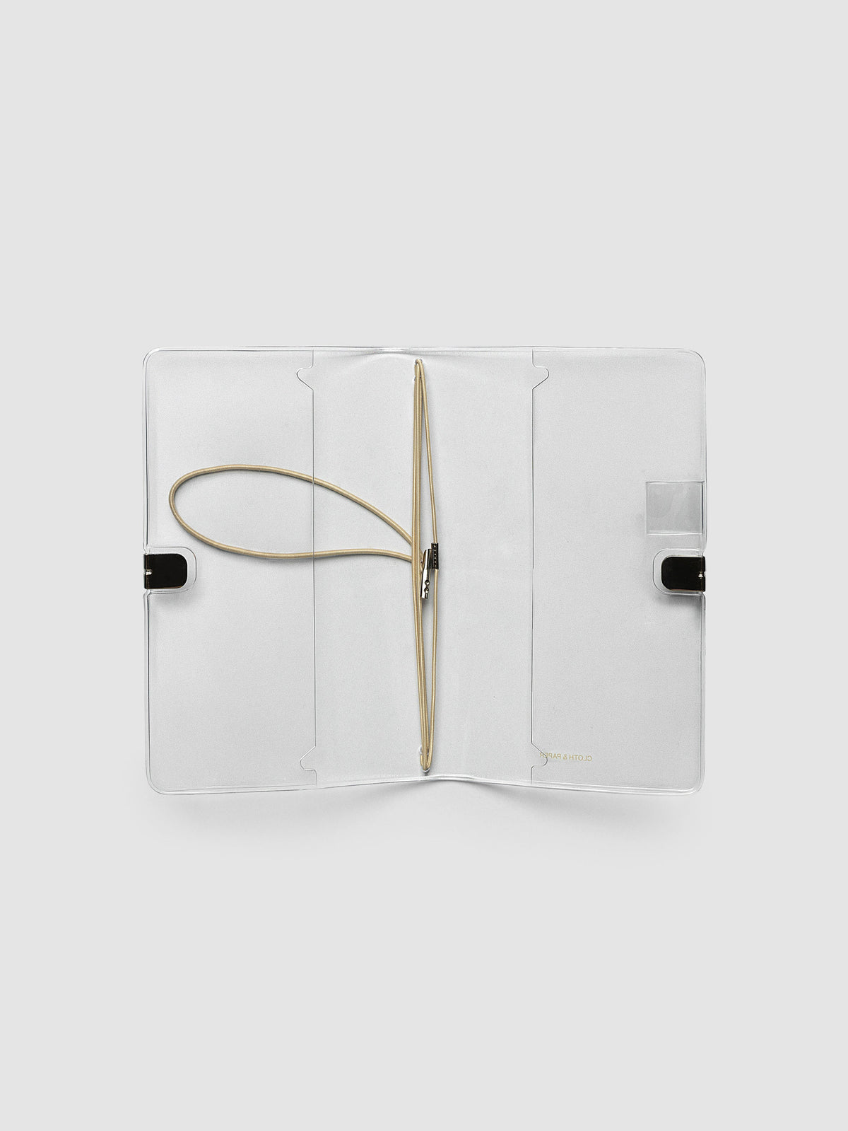Clear Vinyl Travel Notebook Cover in Pocket Plus shown open flat with the interior pockets and bungee strings visible.