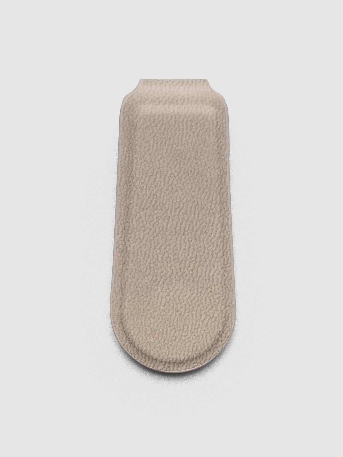 Magnetic Bookmark Smooth Leather in light taupe, close-up angled view of embossed Cloth & Paper mark on rounded end