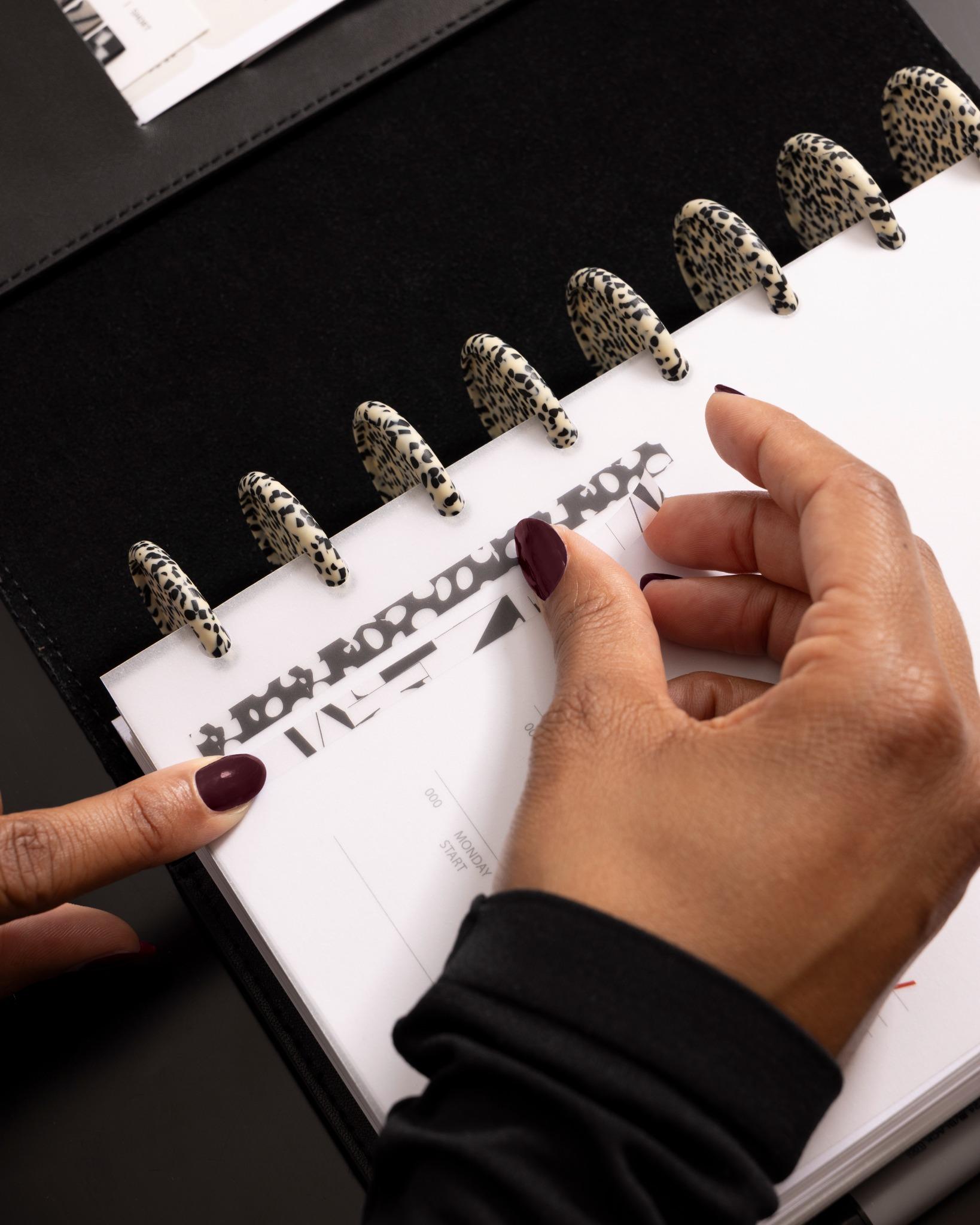 Applying a black and white patterned Page Pin | Long onto a translucent planner divider