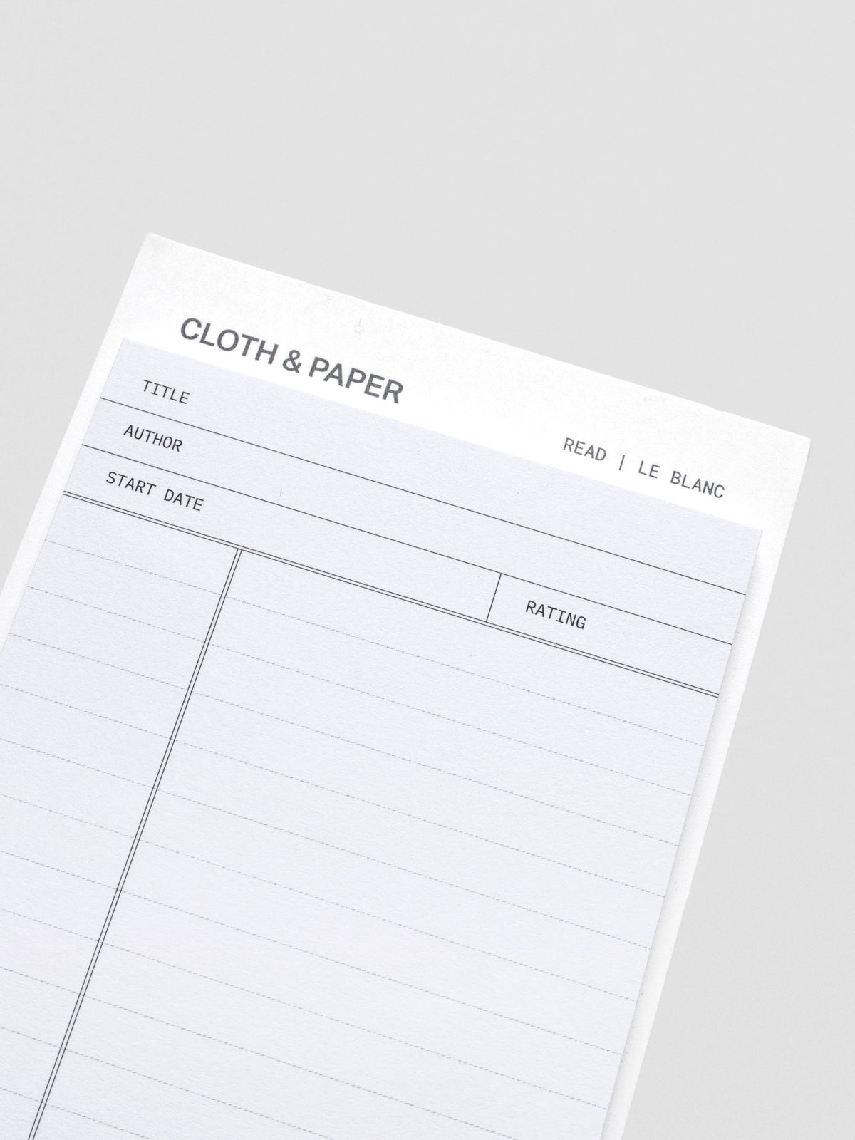 Close up of black and white pad of sticky notes with fields for title, author, start date, rating, and notes section.