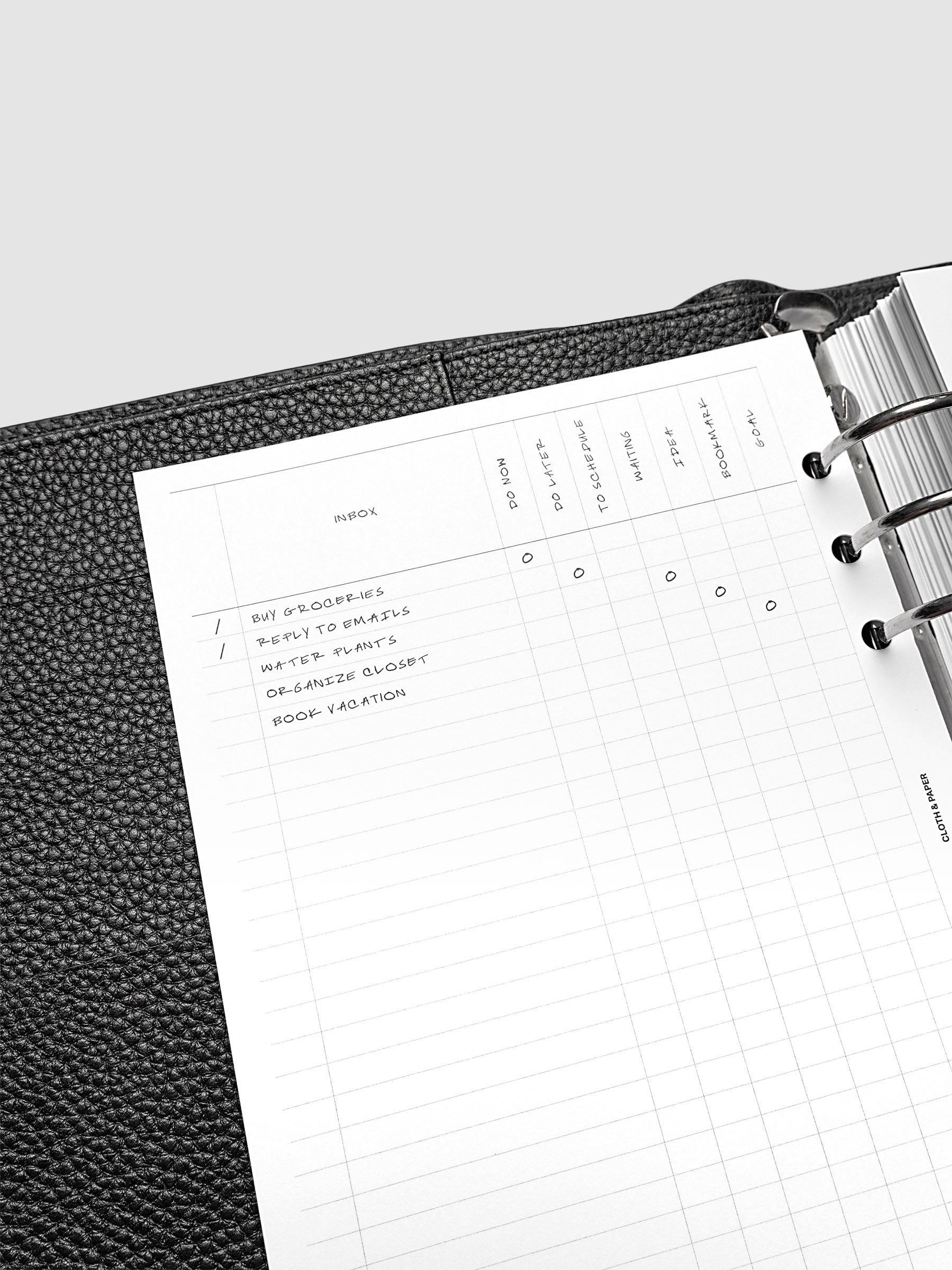 Close up of the demo page for the Inbox Sorting Planner Inserts shown pre-punched for 6-Ring A5 planners in a black agenda.