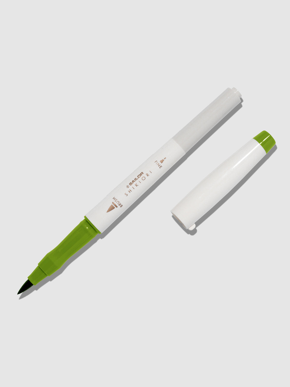Brush pen displayed on a neutral background. It is uncapped with its brush nib exposed, and the cap lying parallel to the marker. Color pictured is Wakauguisu. 