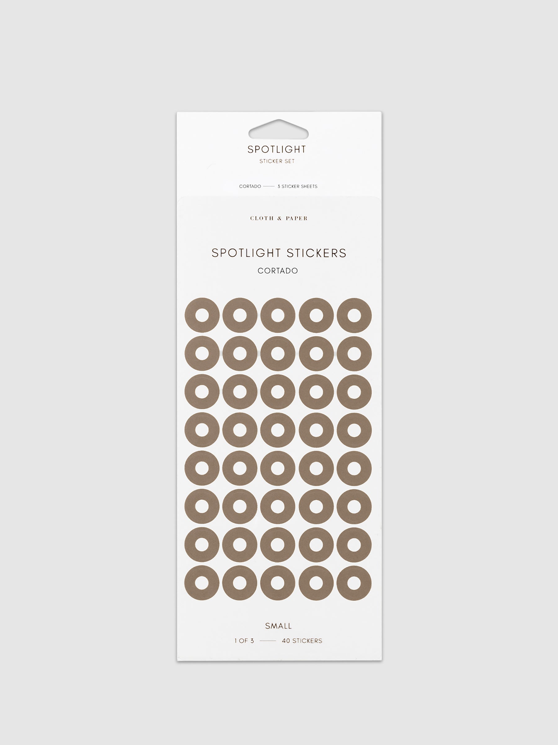 Small sticker in its packaging displayed on a neutral background. Pictured color is cortado.