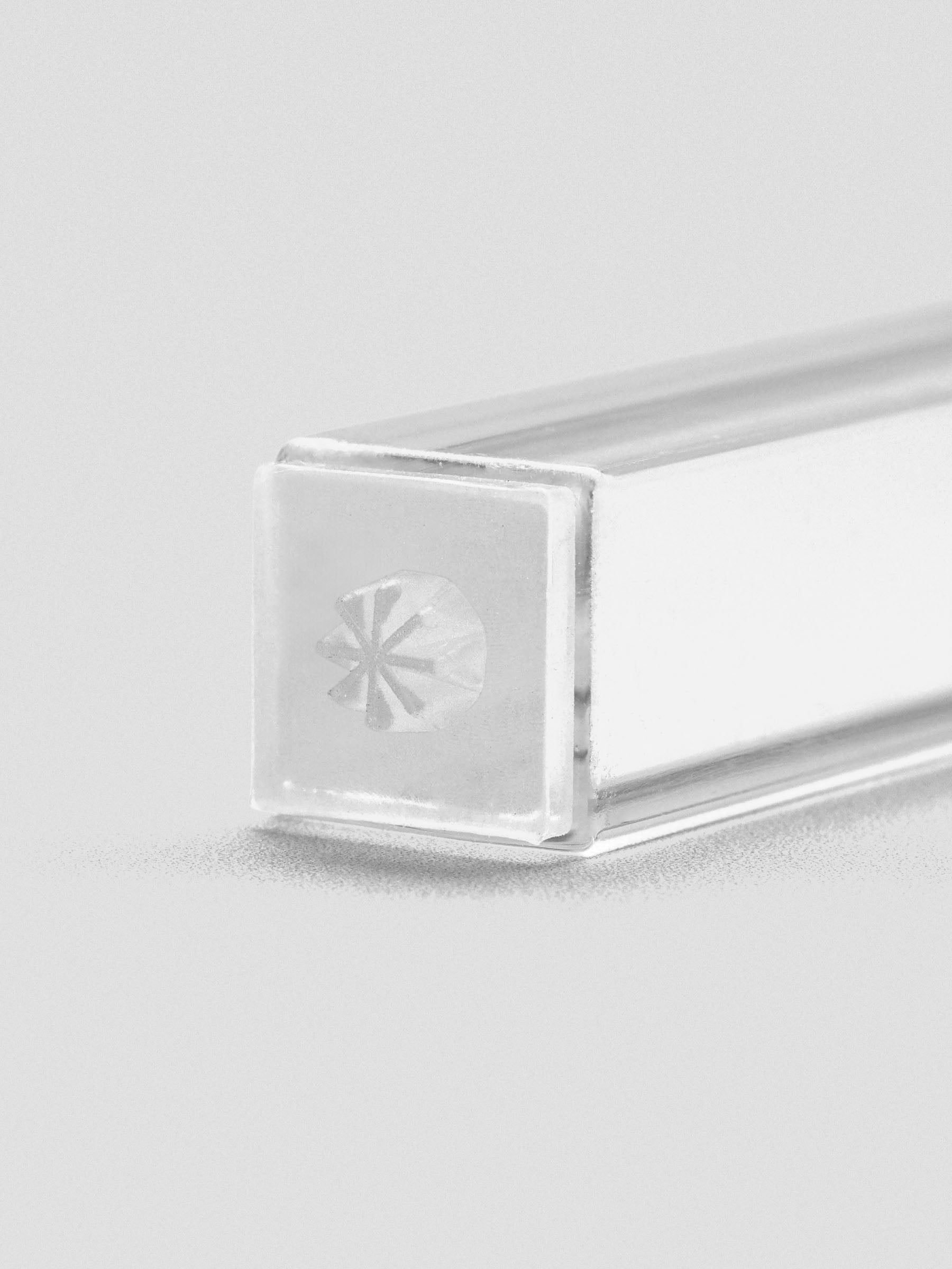 Close-up of stamp stick end with an engraved asterisk icon.