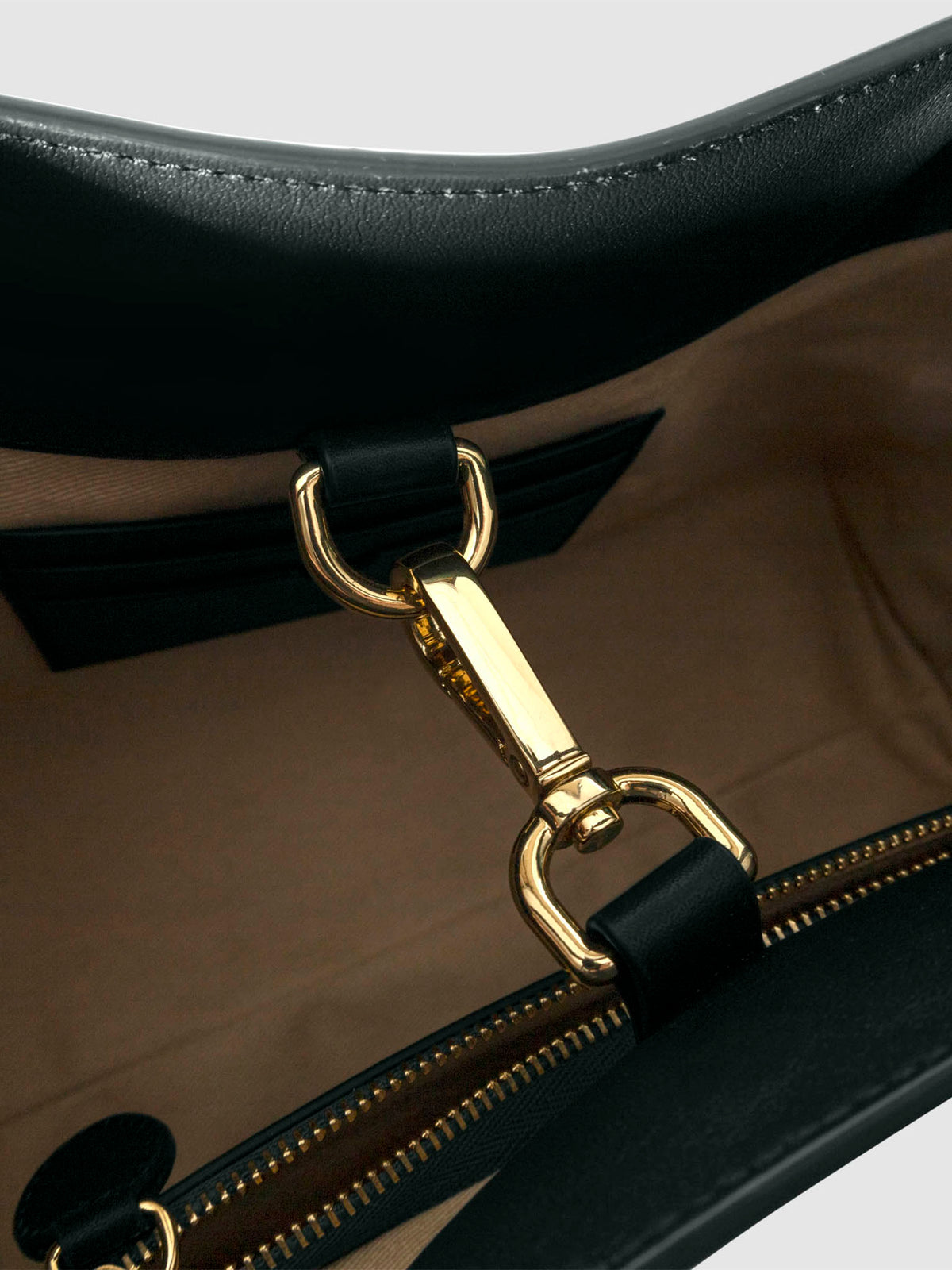 Top down view of bag showcasing its gold hardware. It secures the bag shut. Color shown is Salamanca.