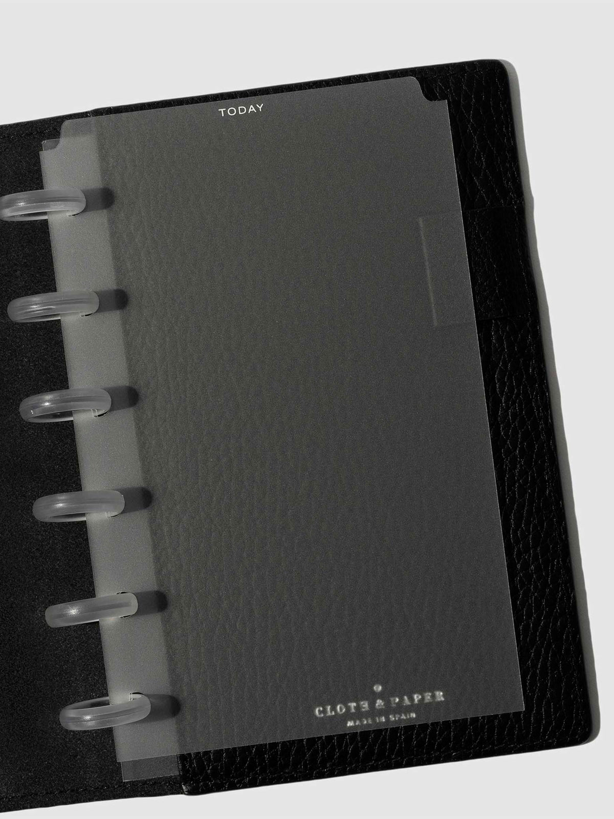 White  foil divider displayed in a black leather planner.