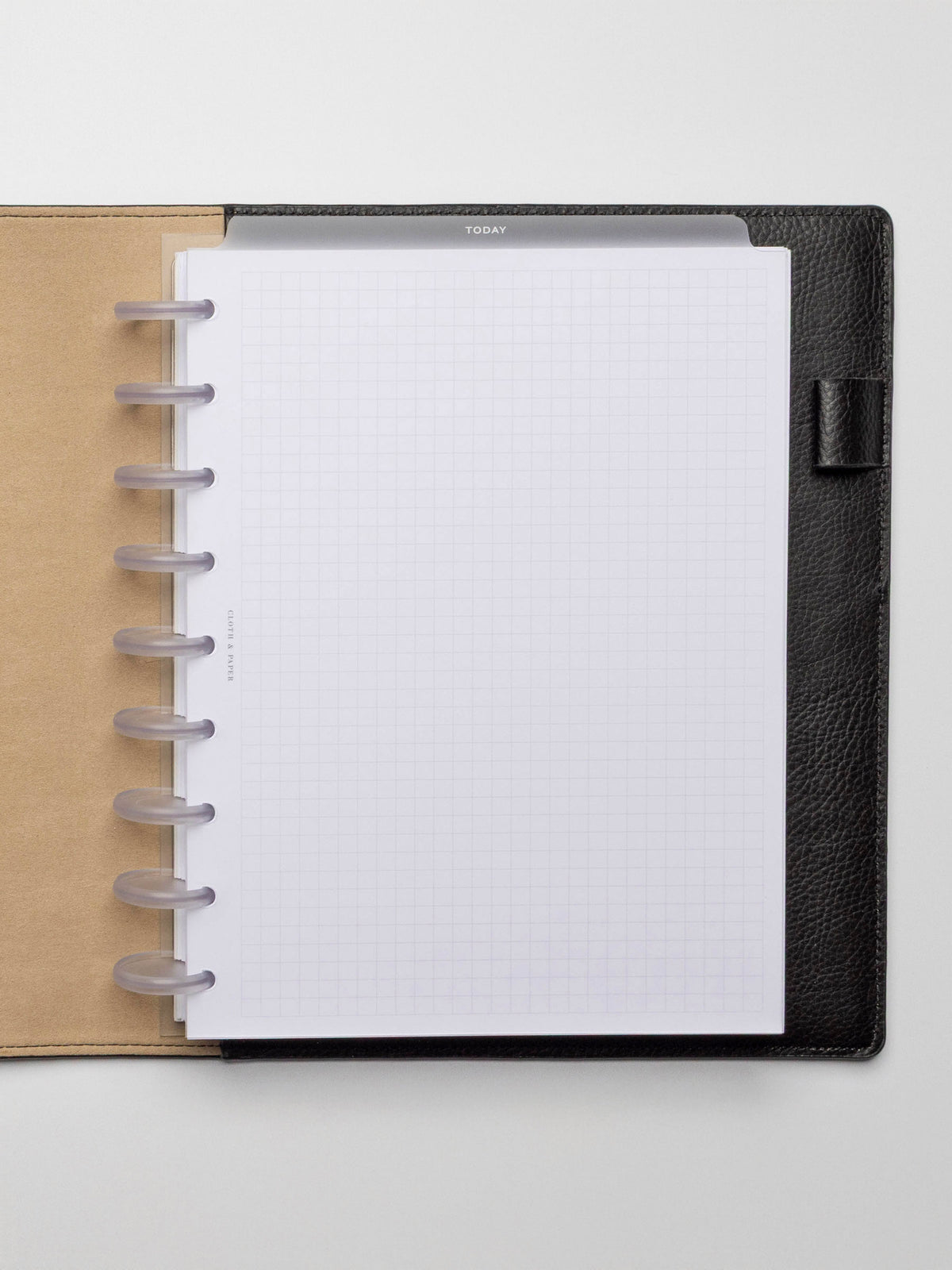 White foil divider displayed in a black leather planner.