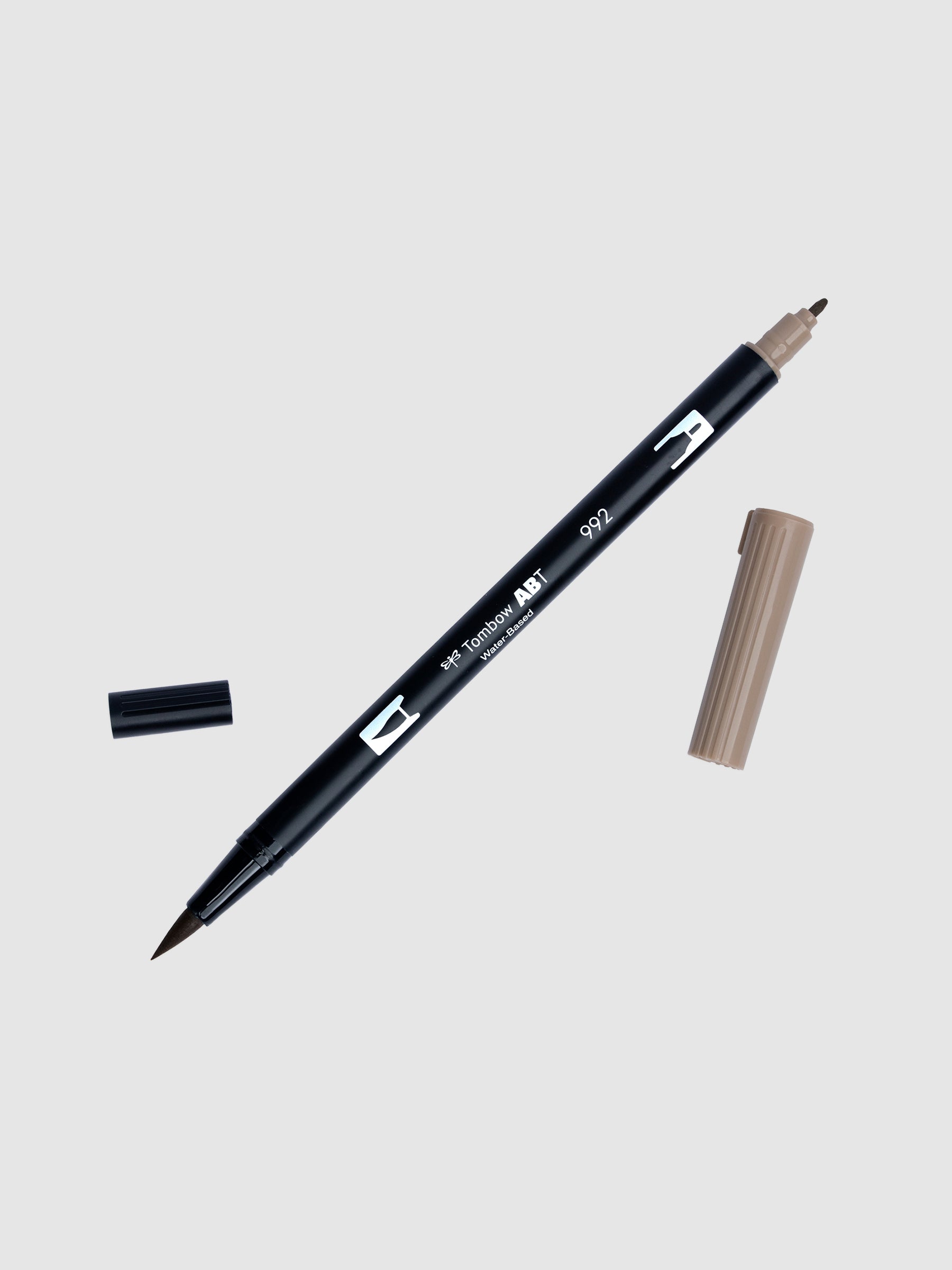 Art marker in Sand turned slightly to the right on a neutral background. It is uncapped on both ends showing the brush tip and fine tip.