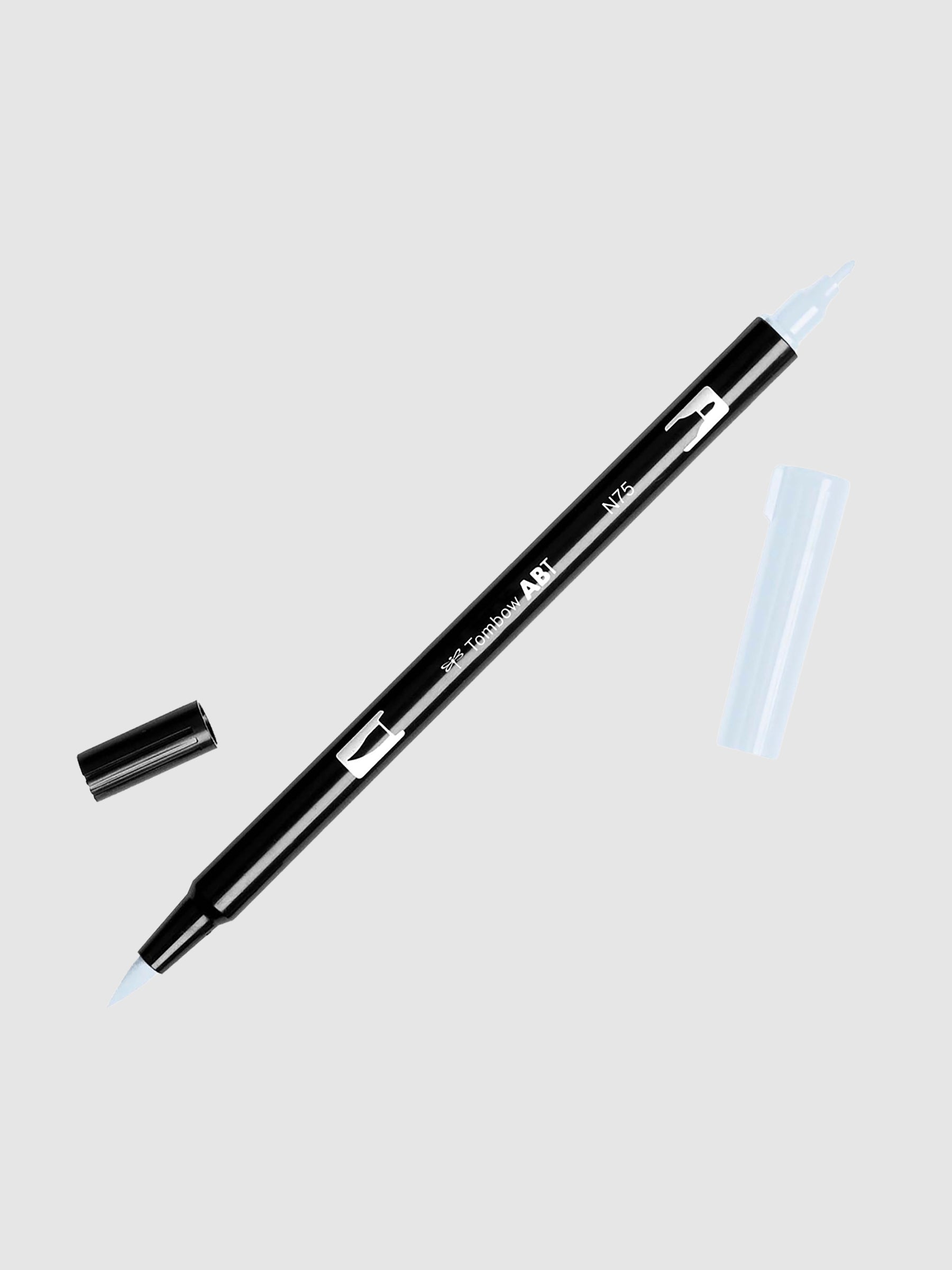 Tombow Dual Brush Art Marker, Cool Gray 3, Cloth & Paper. Art marker turned slightly to the right on a neutral background. It is uncapped on both ends showing the brush tip and fine tip.