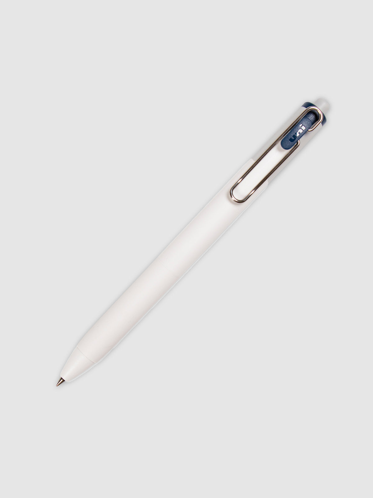 Uni-ball One Gel Pen, Blue Black, Cloth and Paper. Pen tilted slightly to the right on a neutral background.