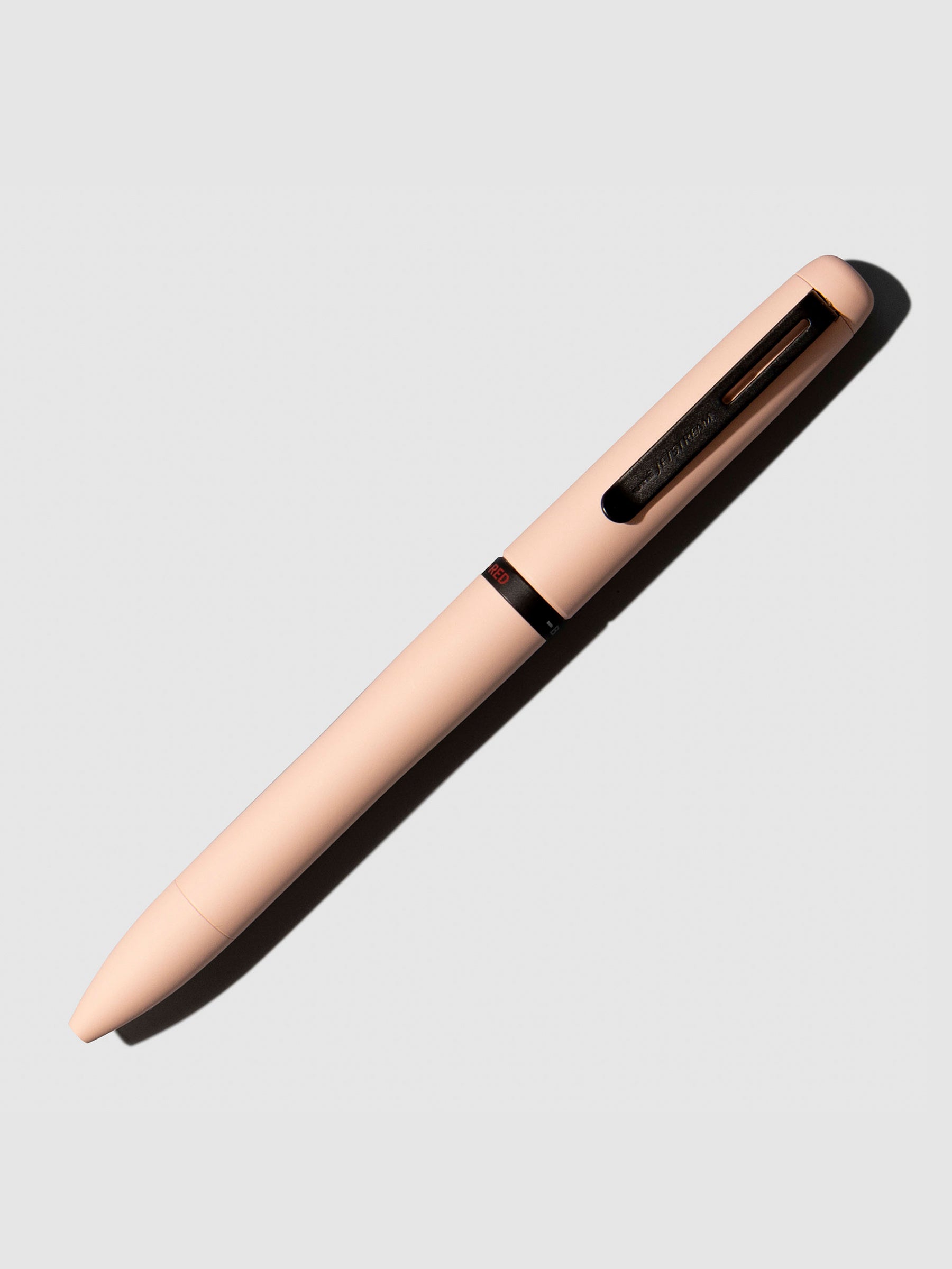 Uni Jetsream Prime Light Touch Gel Pen, Cloth and Paper. Pen shown on a neutral background with its tip retracted. Color shown is Cotton Pink.