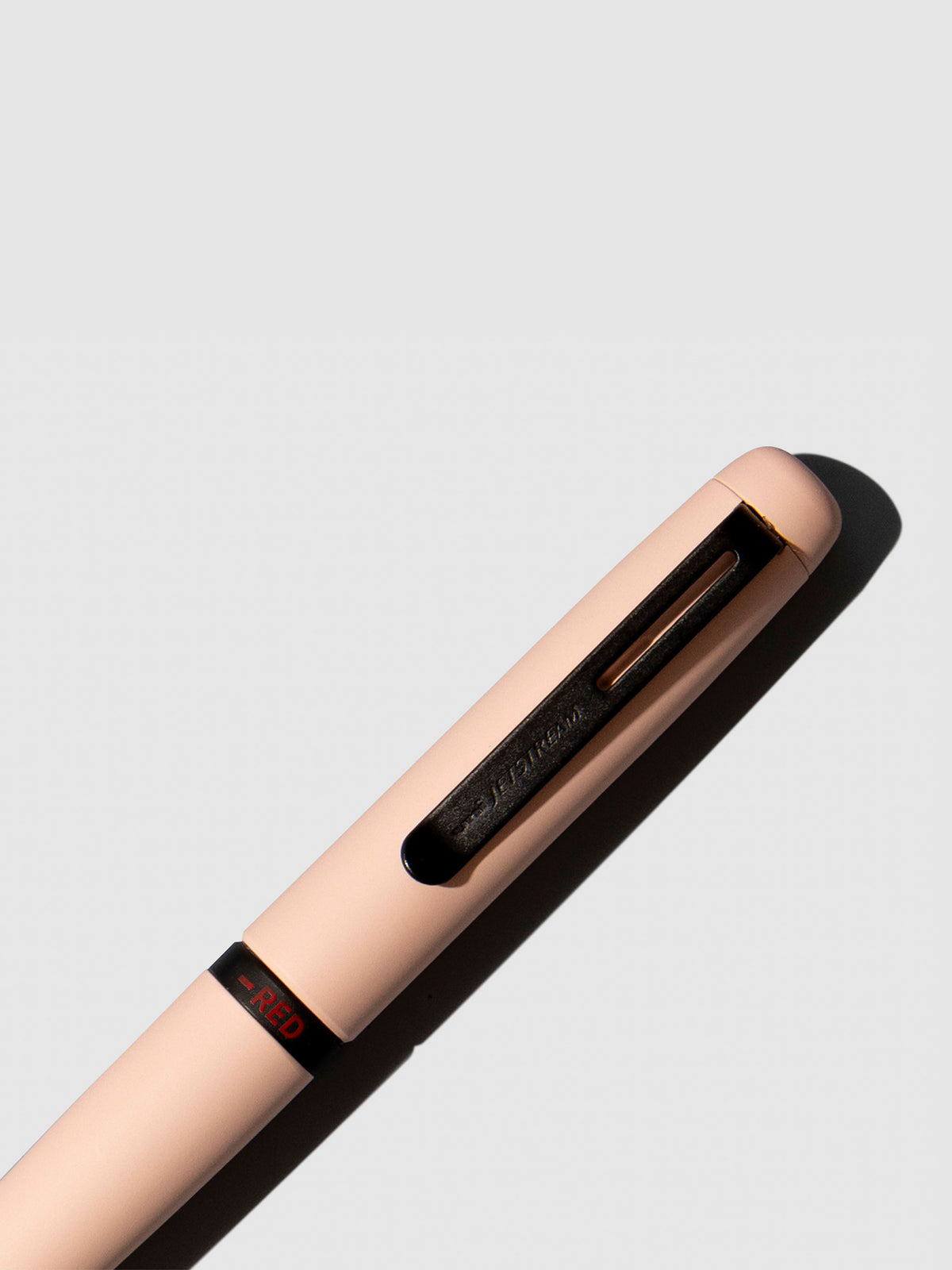 Pen shown close up, with the color selecting ring in focus. Pen ink color selected is red, pen body is Cotton Pink.