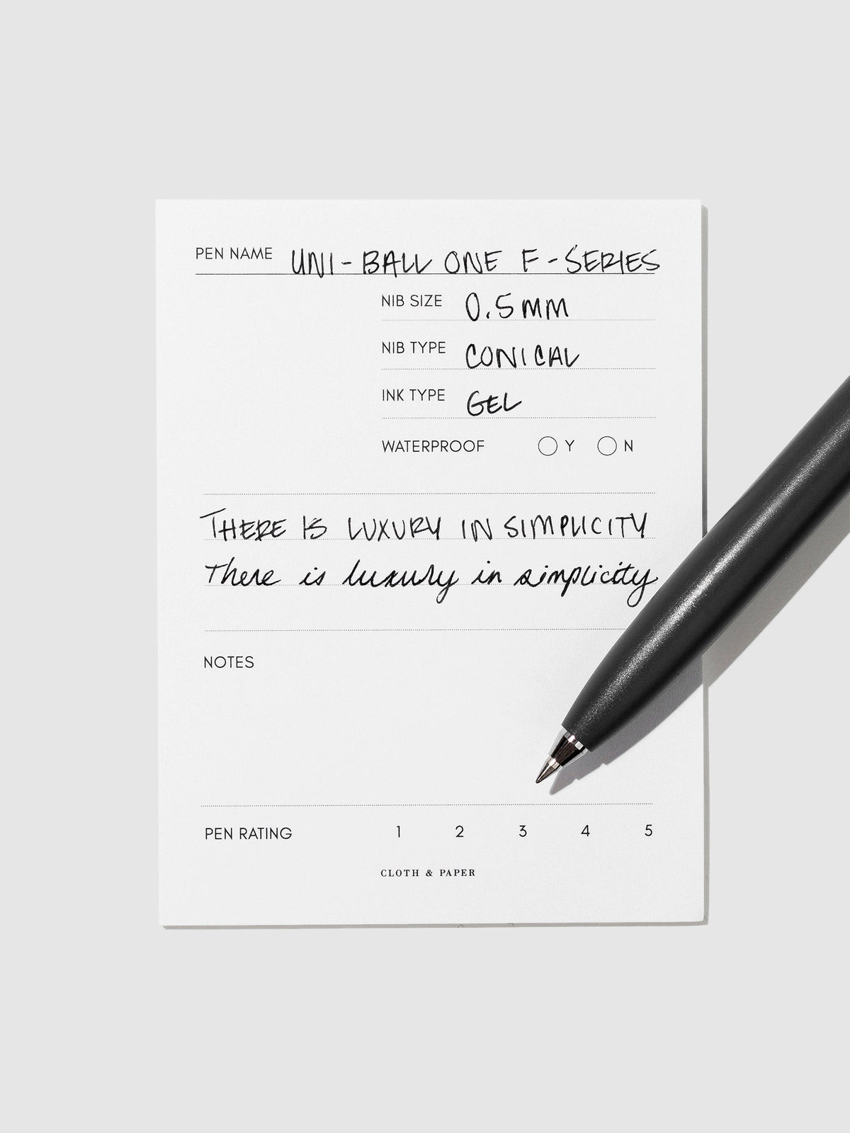 Dark Grey pen resting on an in use pen test sheet.