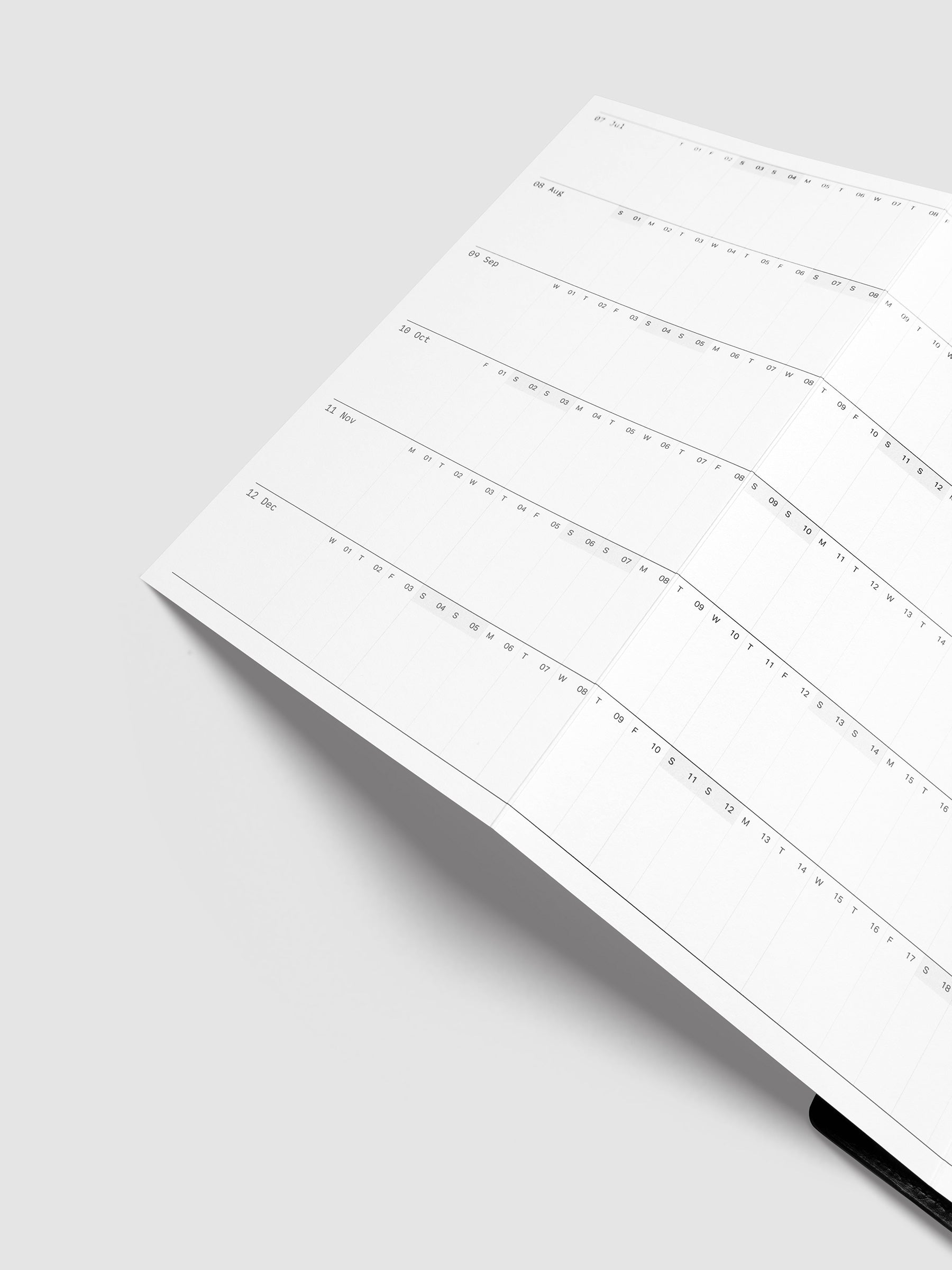 Detail view of the 2027 Dated Fold Out Insert fully unfolded inside a Half Letter 8-Disc Punch discbound planner, showing six months of dated calendar boxes across one side.
