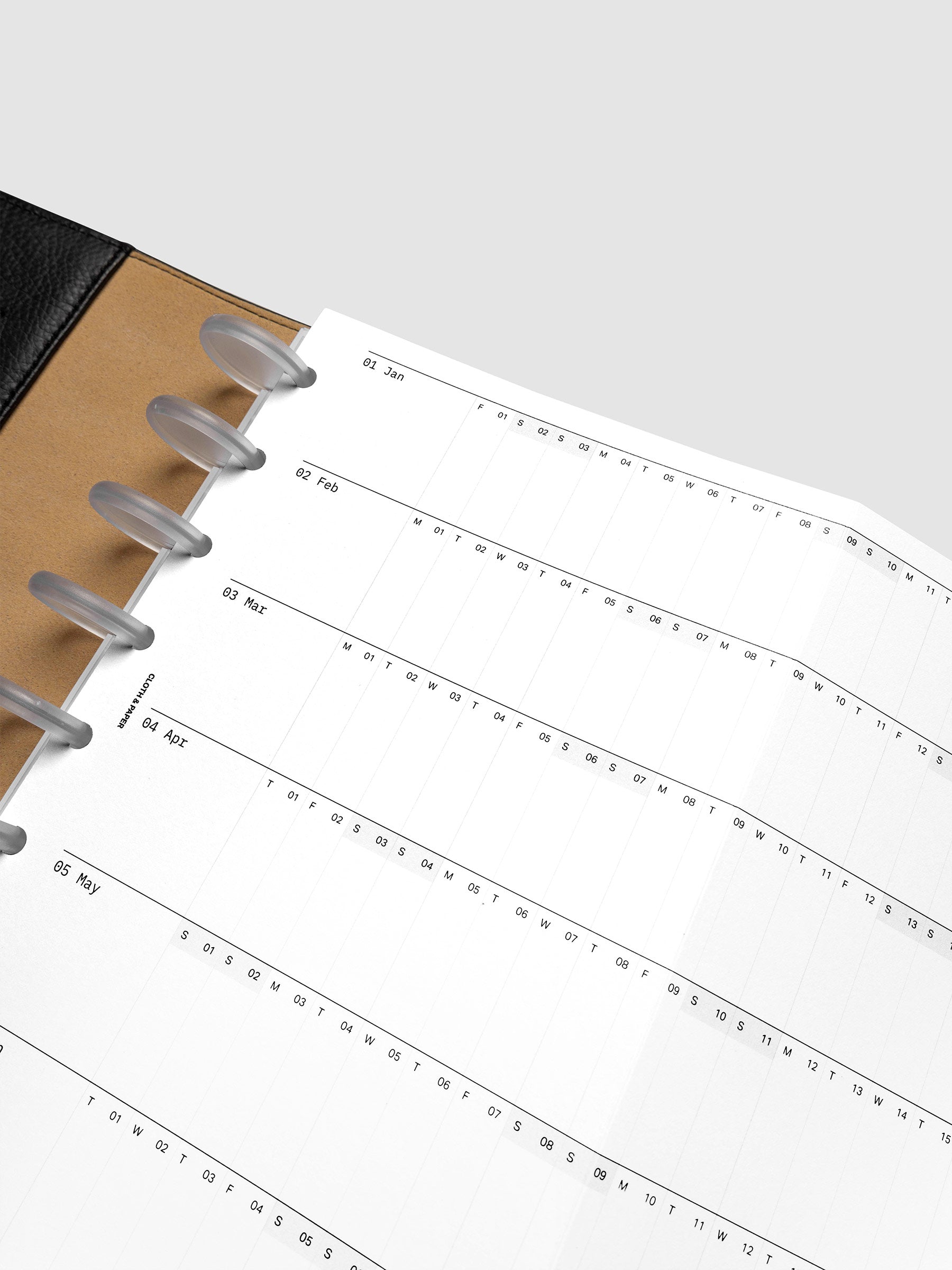 Detail view of the 2027 Dated Fold Out Insert fully unfolded inside a Half Letter 8-Disc Punch discbound planner, showing six months of dated calendar boxes across one side.