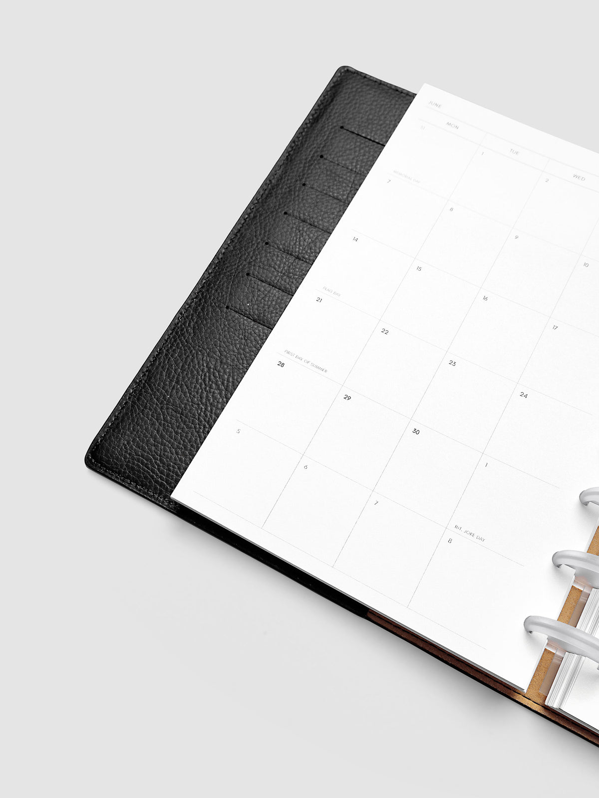 2027 Dated Monthly Planner Inserts, Monday Start, Half Letter 8-Disc Punch, close-up detail of left page showing holidays and observances labeled on monthly calendar shown inside a planner