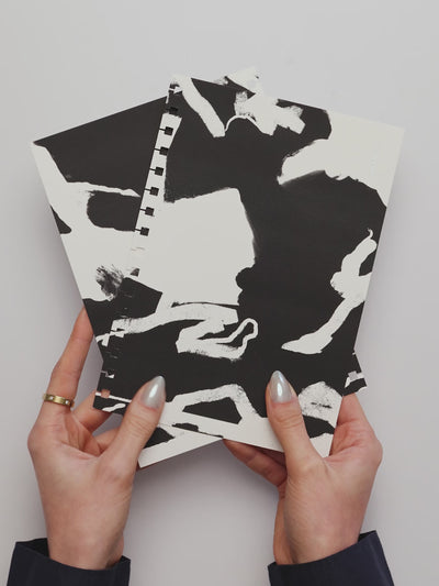 A person inserting the Spiral Notebook Dashboard Set into a spiral planner.