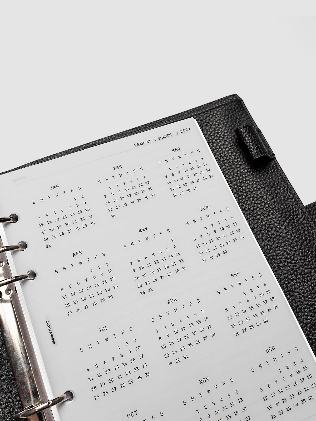 2027 Year At A Glance Dashboard Sunday Start, A5 6-Ring Punch, close-up of the top of the vellum dashboard showing the first months of the 2027 year-at-a-glance calendar in Sunday-start format